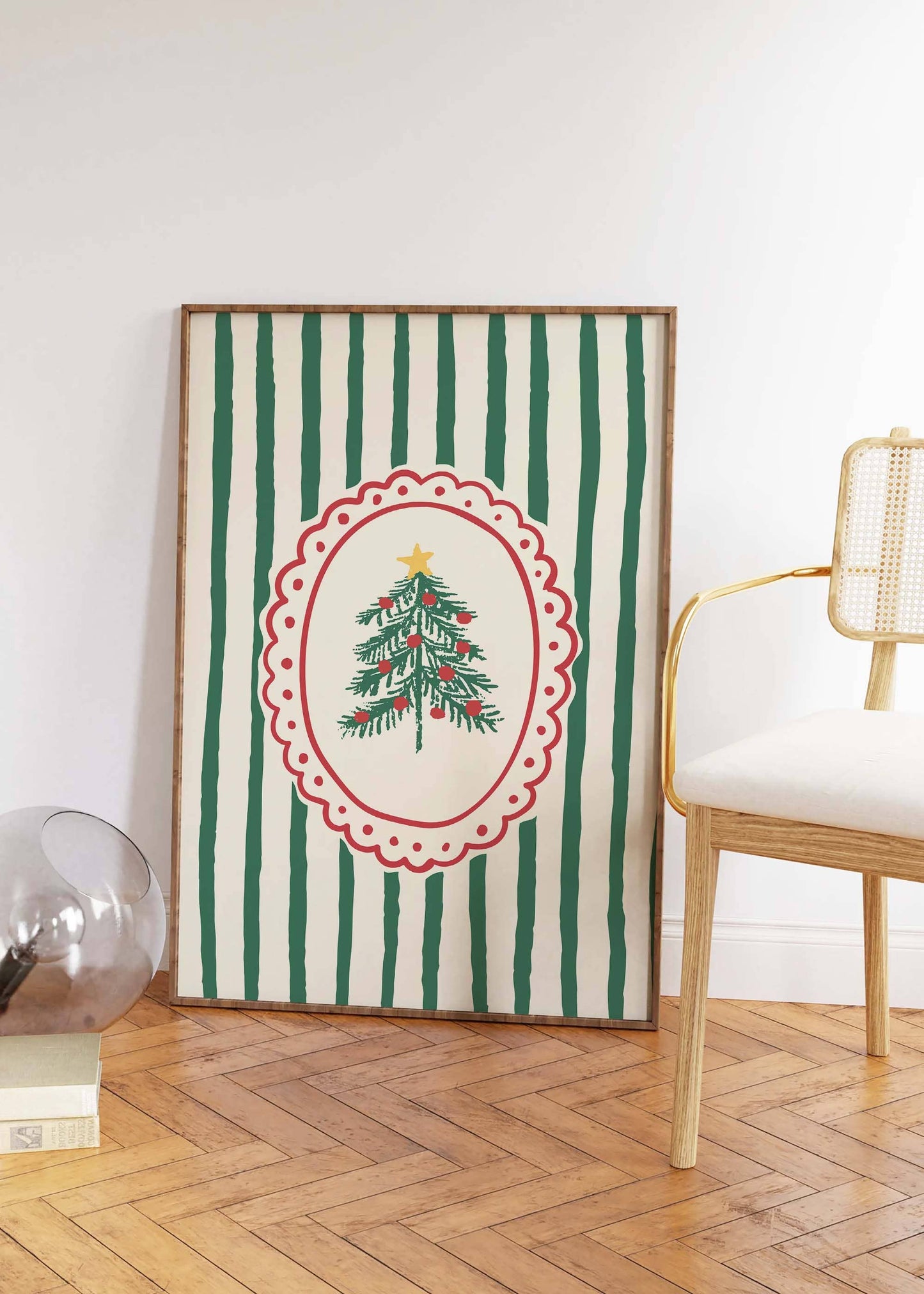 Framed artwork with a Christmas tree design on a striped background, placed on a wooden floor.