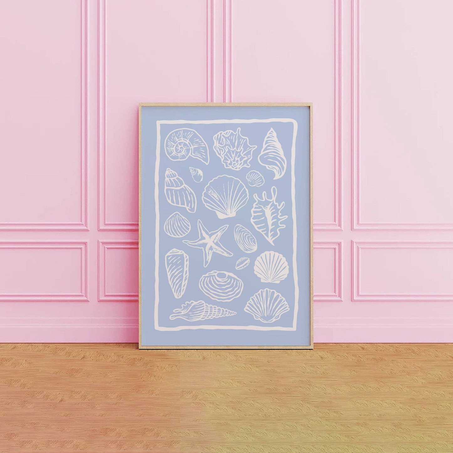 Framed artwork with white shell illustrations on a light blue background, against a pink paneled wall.