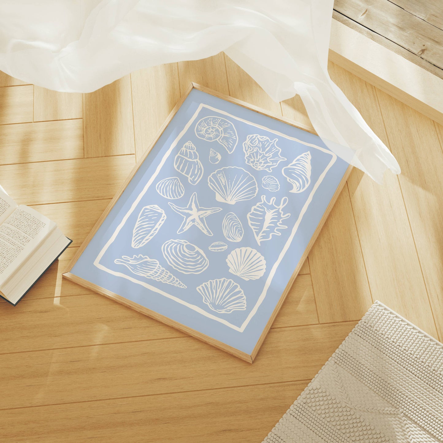 Light blue art print with white shell design on a wooden floor