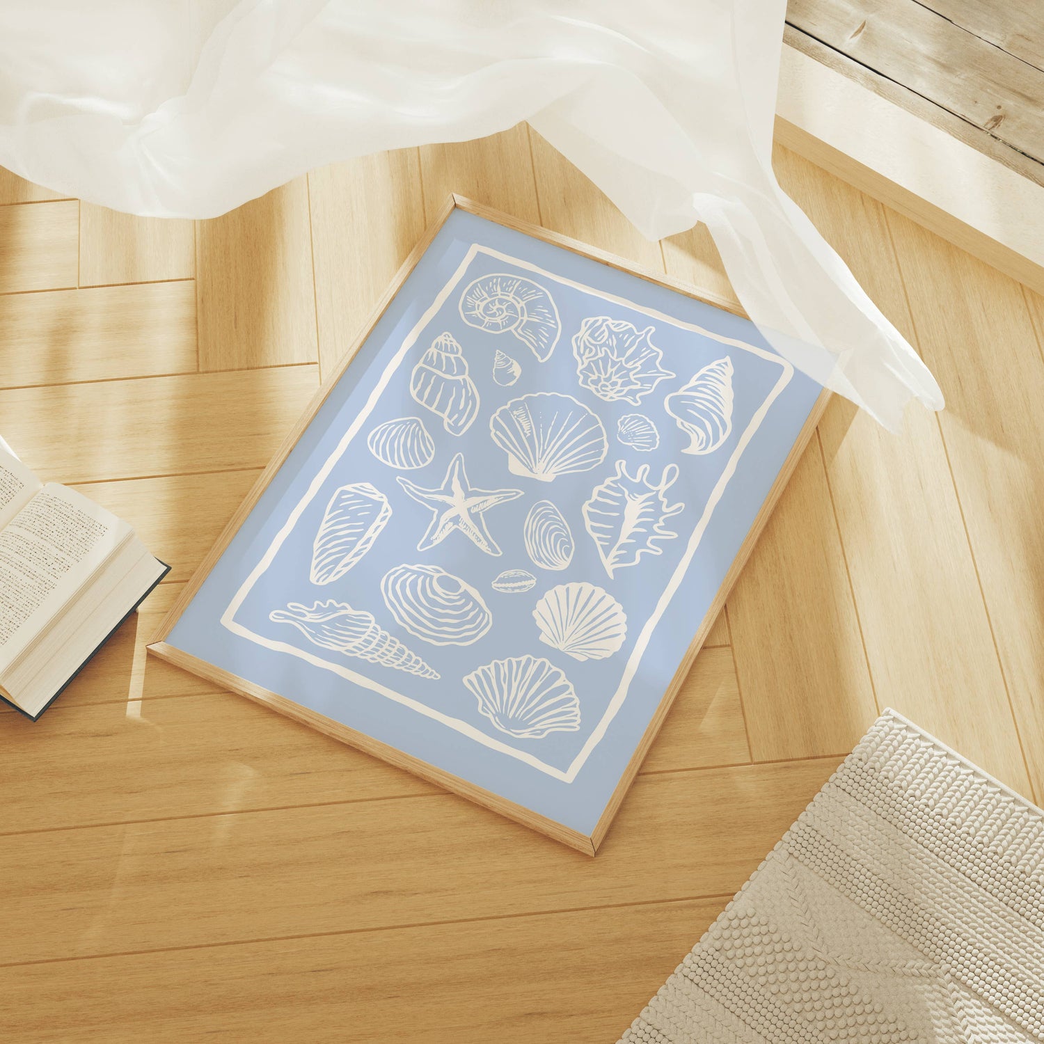 Light blue art print with white shell design on a wooden floor