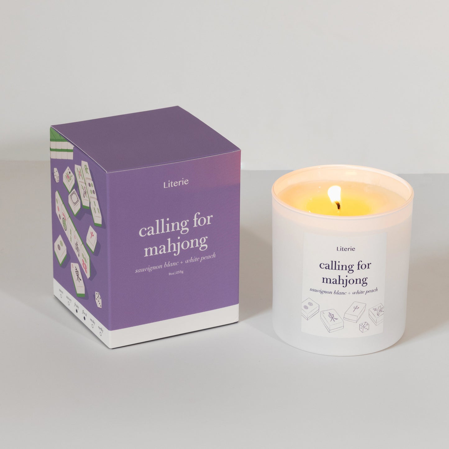 Candle and packaging with 'calling for mahjong' text on a neutral background